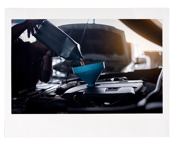technician pouring oiling into a funnel
