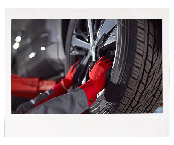 technician installing wheel on a car